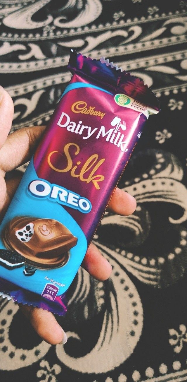 a hand holding a dairy milk silk chocolate bar