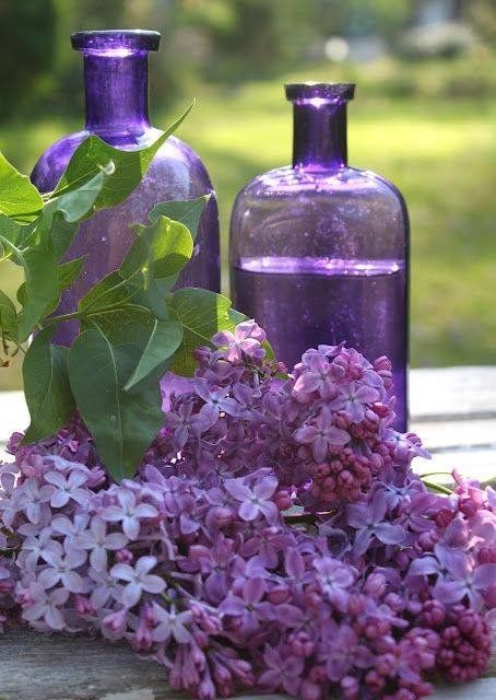 two purple bottles sitting next to each other with flowers in front of them and the words, beautiful april wednesday blessings