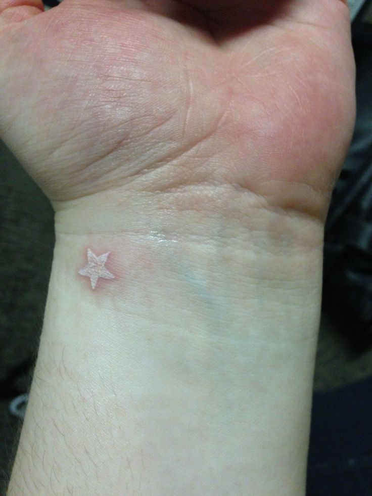 a small star tattoo on the wrist is seen in this image, it appears to be tiny