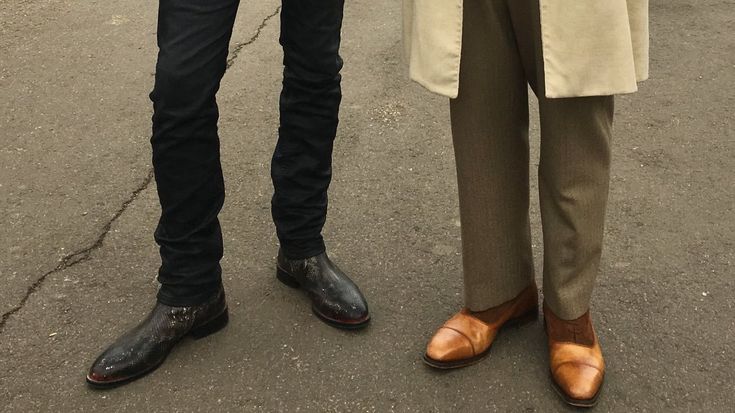 two men standing next to each other in the street