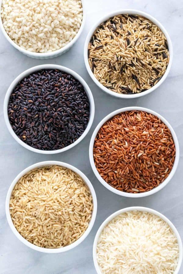 six bowls filled with different types of rice on a white table top next to each other