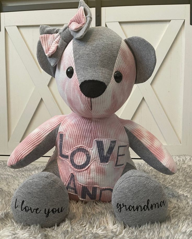 a teddy bear with love and grandma written on it's chest sitting on a rug