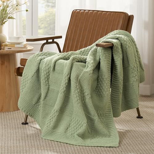 a green blanket sitting on top of a wooden chair