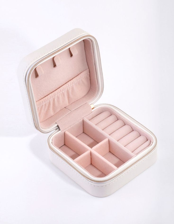 an open white box with compartments for jewelry on a white surface, showing the inside