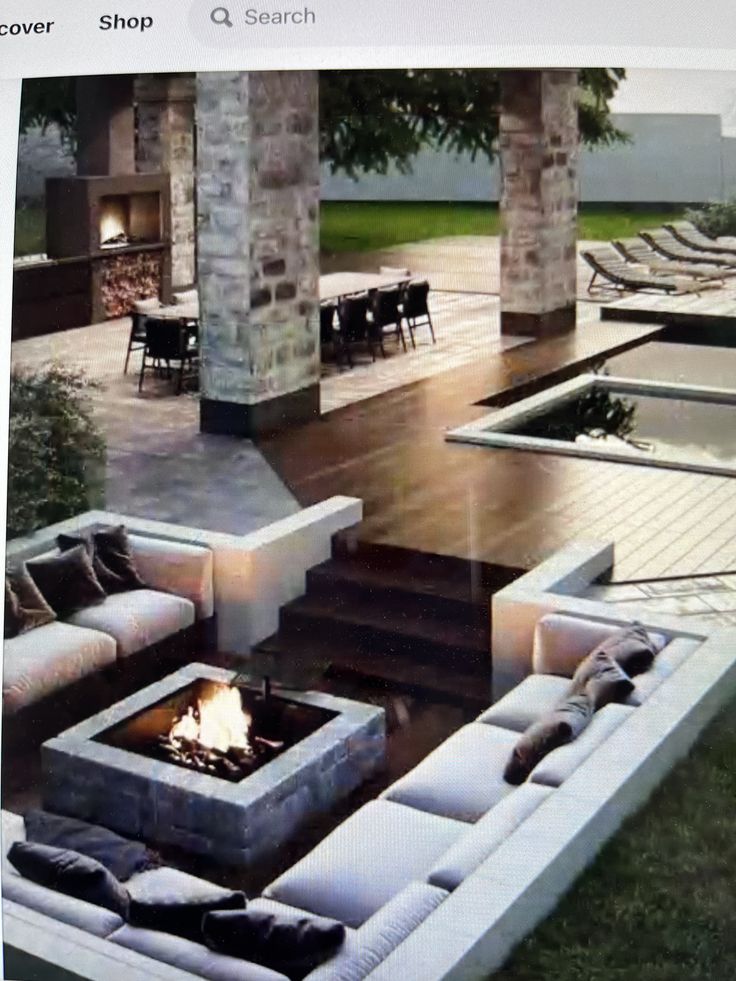 an outdoor living area with couches and fire pit