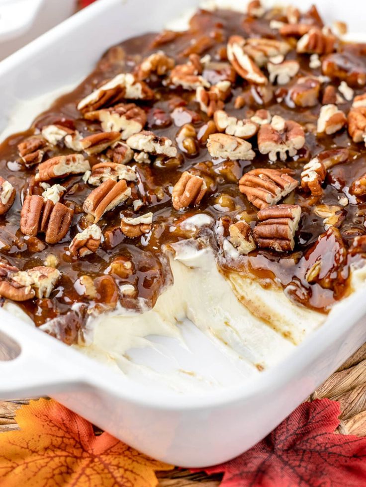 a white dish filled with ice cream and pecans