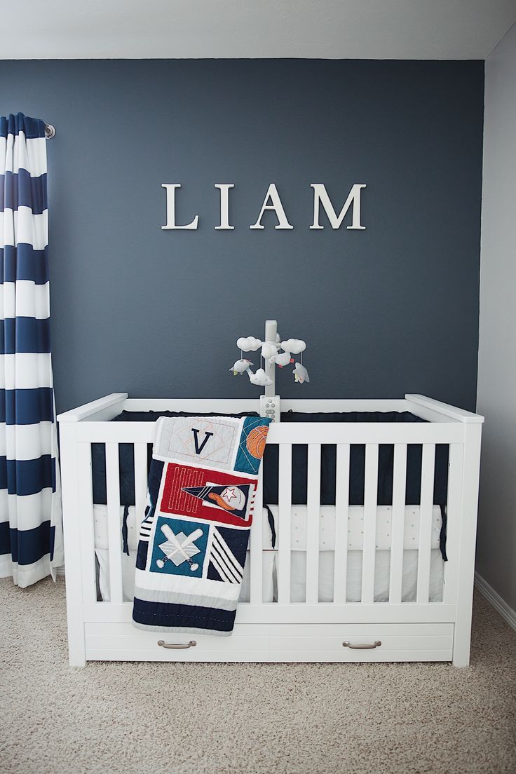 a baby's room with a crib and name sign above the crib