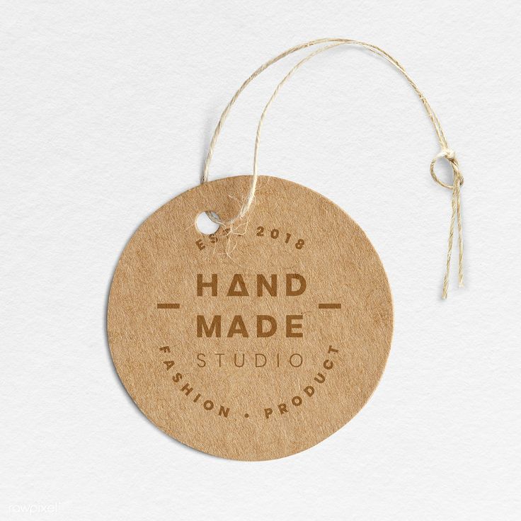 a round wooden ornament hanging from a string on a white background with the words hand made studio written across it