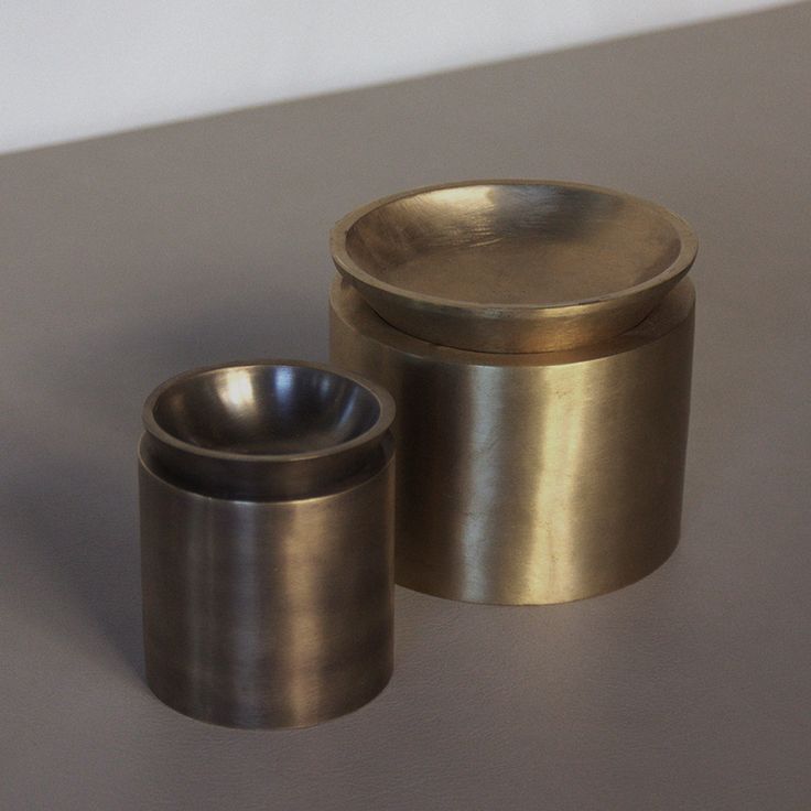 two metal containers sitting on top of a table