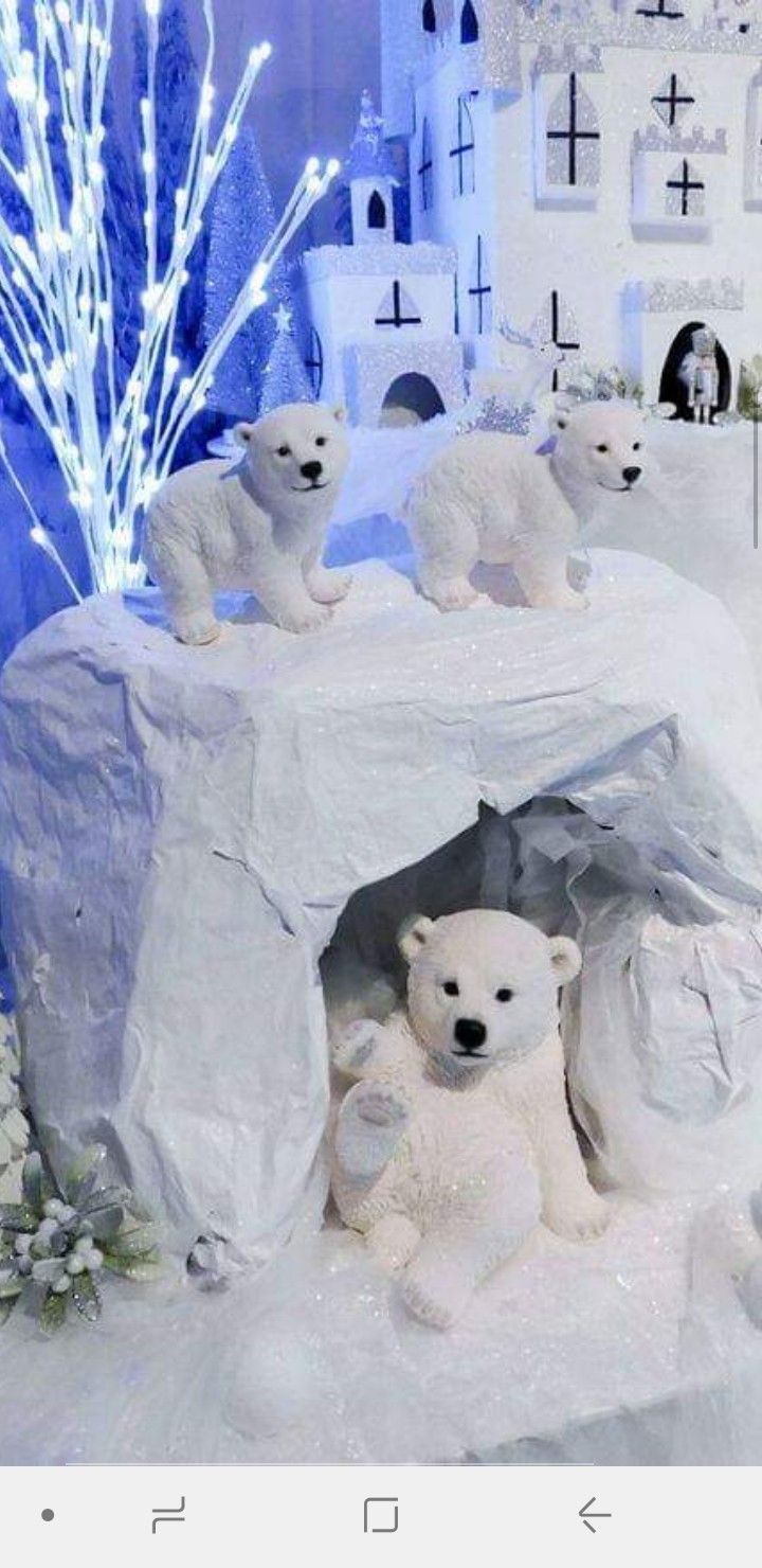 there are polar bears in the snow with lights on behind them and an igloose