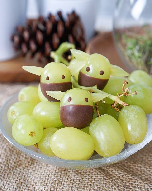 grapes with googly eyes are on a plate