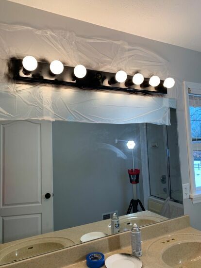 a bathroom mirror that has lights on above it