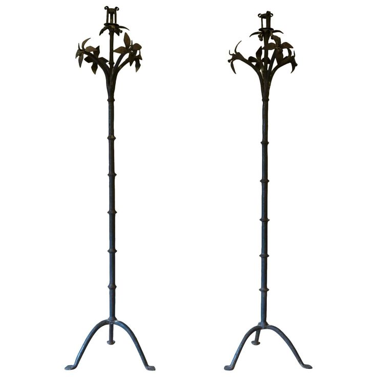 two tall metal flower stands with flowers on them