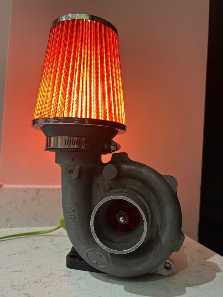 a red light sitting on top of a table next to a blow dryer fan