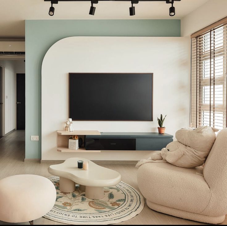 a living room filled with furniture and a flat screen tv mounted to the side of a wall