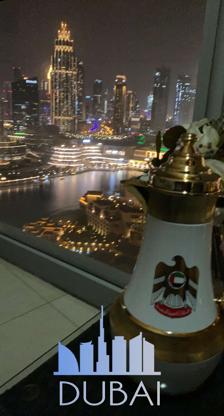 a lamp on top of a table in front of a window overlooking a cityscape