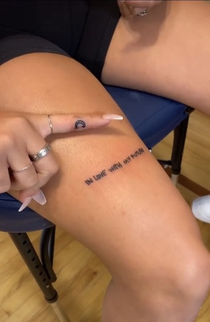 a woman sitting on top of a chair with her finger pointing at the word i love you