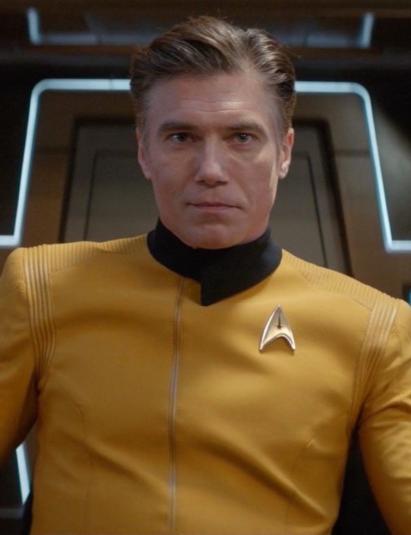 a man in a star trek uniform looking at the camera