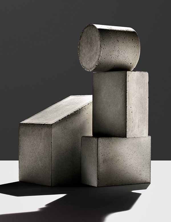 concrete blocks stacked on top of each other in front of a gray background with shadows