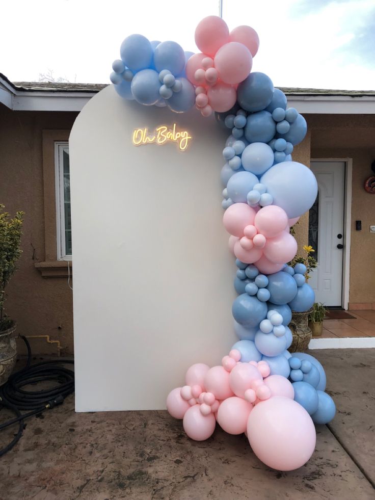 a balloon arch with blue, pink and white balloons