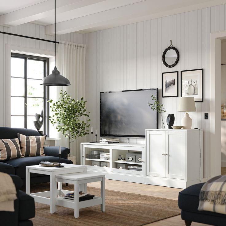 a living room filled with furniture and a flat screen tv on top of a white entertainment center