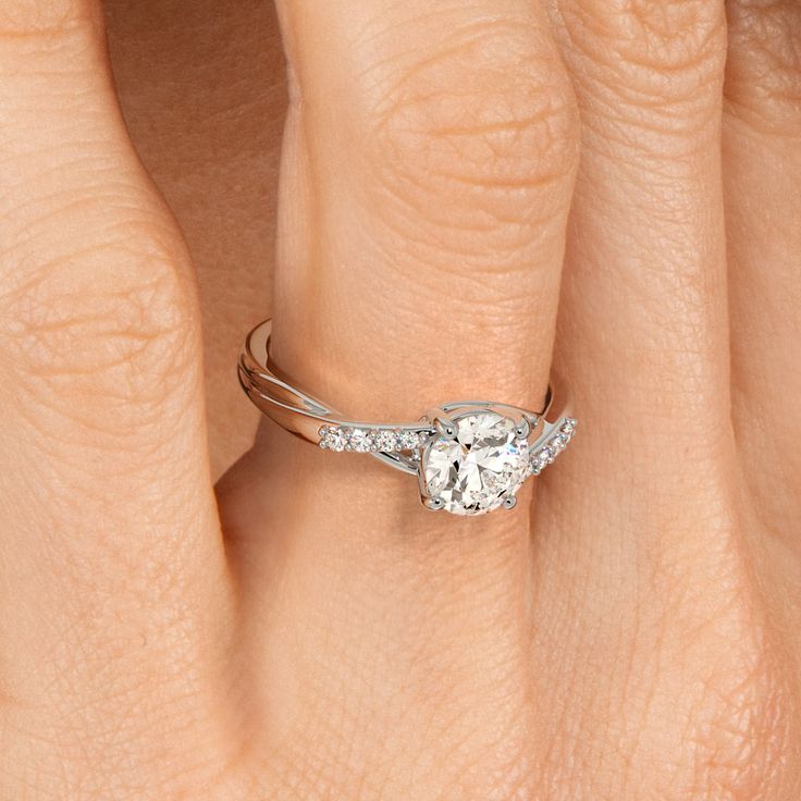 a woman's hand with a diamond ring on her finger and an engagement band