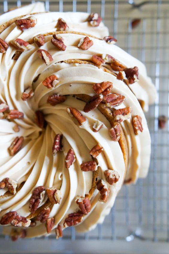 a cake with white frosting and pecans on top