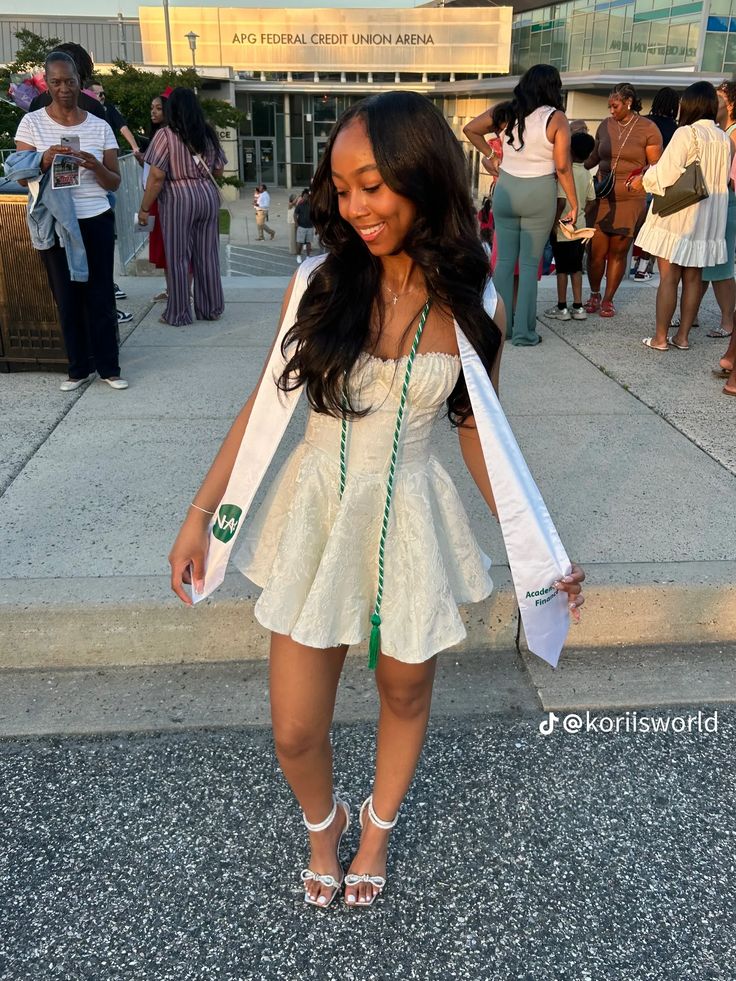 a woman in a white dress is walking down the street with her hand on her hip