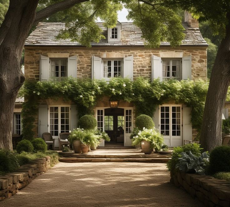 a large house with lots of windows and plants growing on the side of it's front door