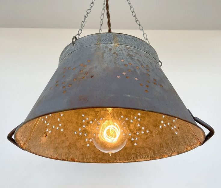 Beautifully weathered Star Colander creates the perfect Farmhouse galvanized pendant lighting for over your country kitchen sink or rustic kitchen island! Capture the relaxed ceiling light style with this patina star colander as a chandelier lighting fixture that allows a small glimpse of light through the 'star' and great illumination below Product Details 9″ tall x 12″ wide Weather Star Colander Hanging Light Fixture 14" wide x 10" height Large Weather Star Colander Light Fixture Galvanized Me Diy Rustic Pendant Light, Rustic Hanging Lights, Over The Sink Light, Rustic Island Lighting, Galvanized Light Fixture, Colander Light, Kitchen Lights Ceiling, Rustic Lighting Ideas, Country Kitchen Sink