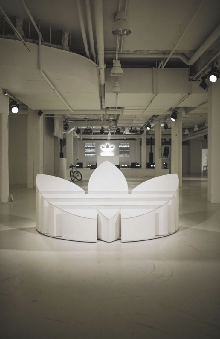 a white bench sitting in the middle of a room with lots of lights on it