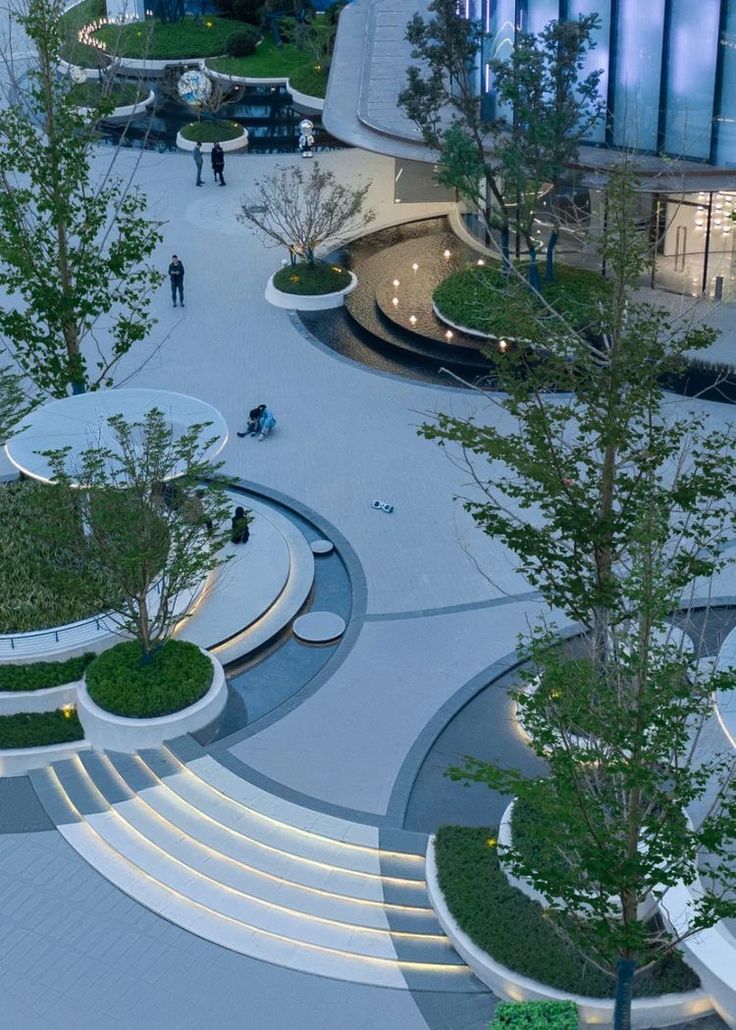 an aerial view of a modern building with circular stairs and trees in the foreground