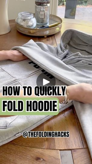 a woman laying on top of a floor covered in a gray blanket with the words how to quickly fold hoodie