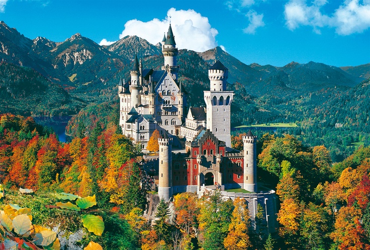 an image of a castle in the middle of trees with mountains in the back ground