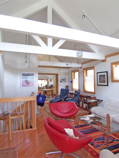 a living room filled with lots of furniture and wooden flooring next to a staircase