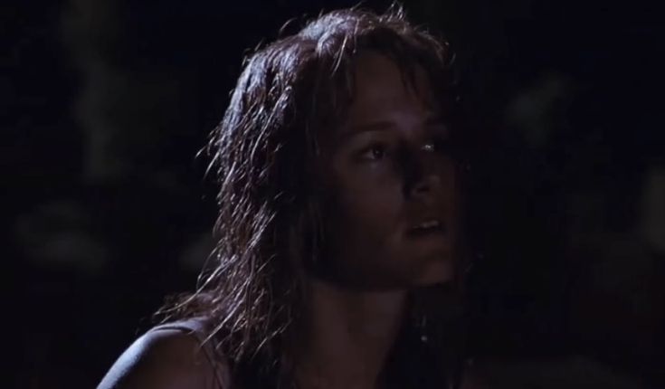 a woman with wet hair standing in the dark