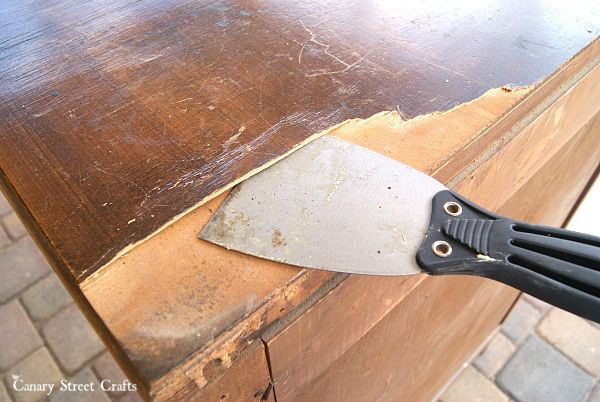 a knife sitting on top of a wooden table next to a brick flooring area