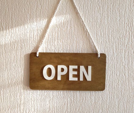 an open sign hanging on the wall