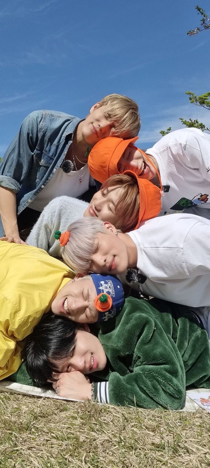 four young boys laying on the ground together with their heads in each others'eyes