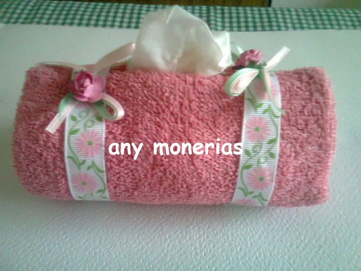 a pink towel with flowers and ribbon on it