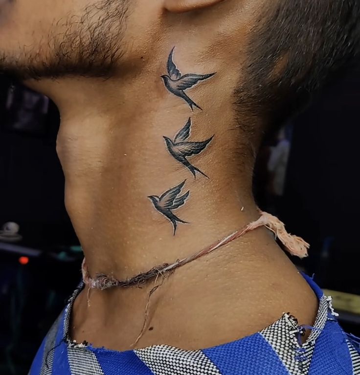 a man with a bird tattoo on his neck