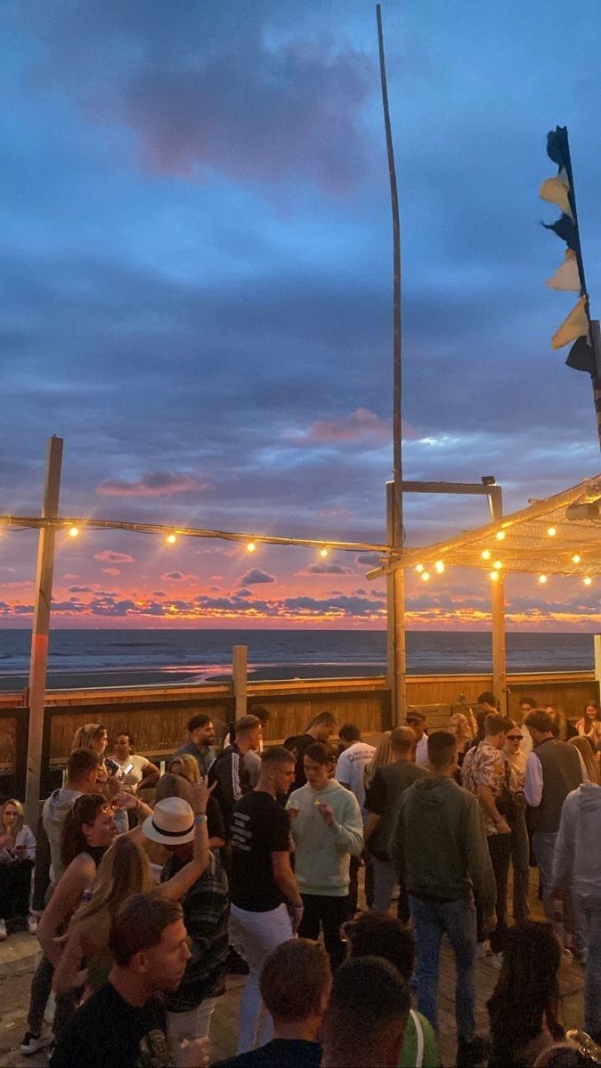 a group of people standing on top of a pier