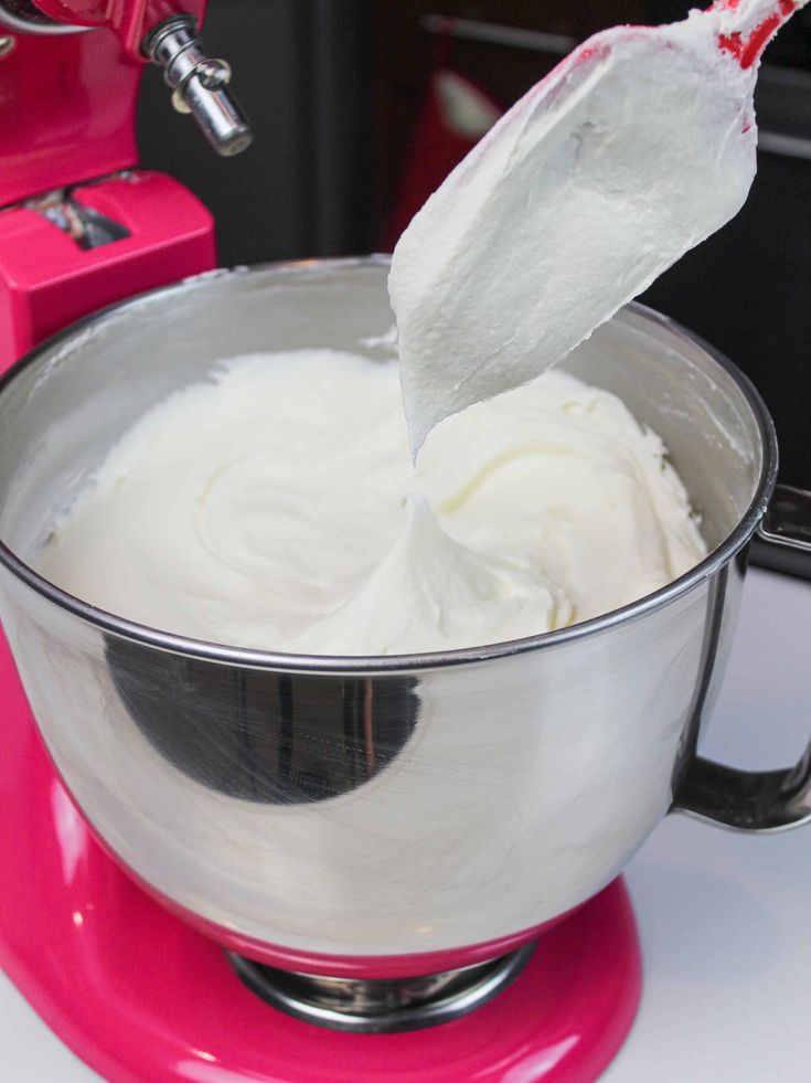 a mixer filled with whipped cream on top of a counter