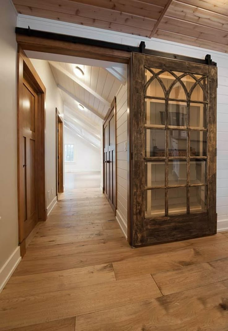 an open door leading to a hallway with wood floors and white walls in the background