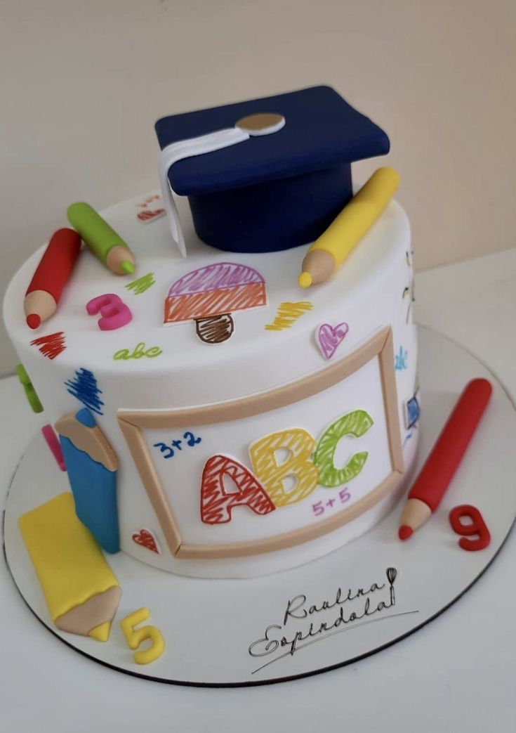 a decorated cake with pencils, crayons, and graduation cap on it