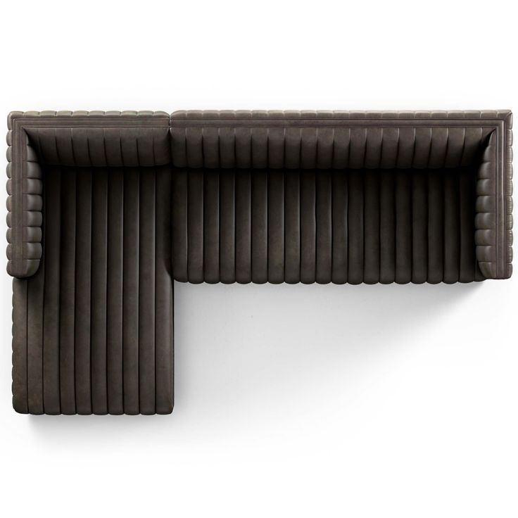 an overhead view of a brown couch on a white wall