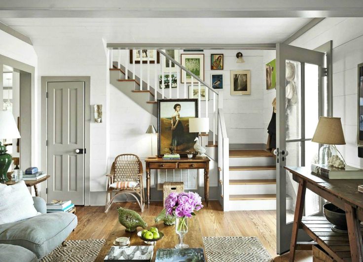 a living room filled with furniture and a stair case in front of a doorway leading to a second floor