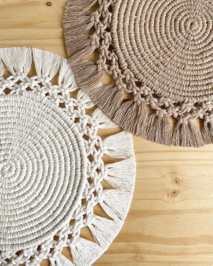 two round rugs with tassels on top of them sitting on a wooden floor