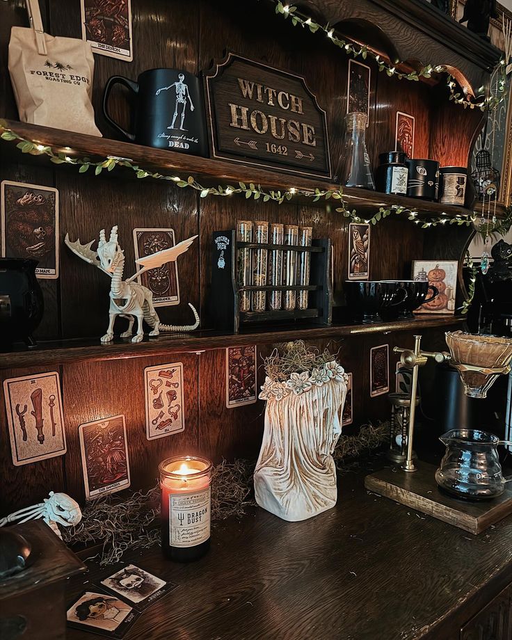 a wooden shelf filled with lots of books next to a candle and pictures on the wall