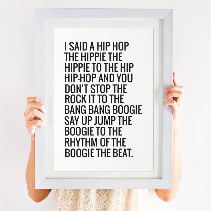 a woman holding up a framed poster with the words, i said a hippie the hippie to the hip and you don't stop the rock it to the bang